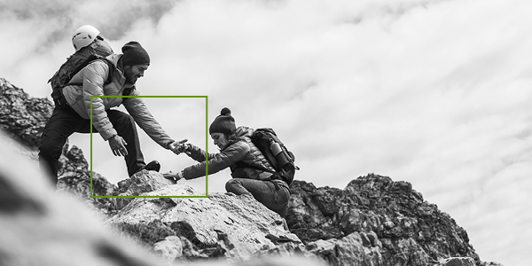 Male and female climbing a mountain.